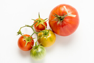 Ripe and green natural tomatoes on a white background. Close up.