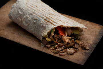 Shawarma  on the wooden desk on black background