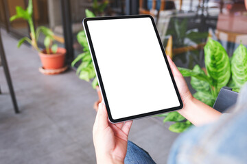 Mockup image of a woman holding digital tablet with blank white desktop screen