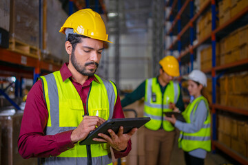 Blue collar workers are working at warehouse.