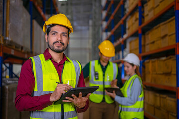 Blue collar workers are working at warehouse.