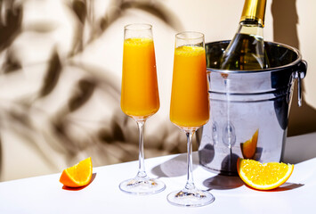 Summer orange cocktail drink with juice and dry champagne or sparkling wine. Beige background, hard...