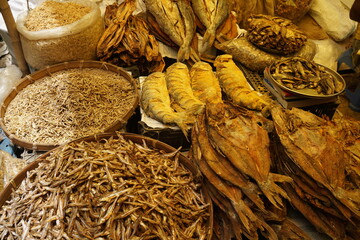 Mixed dried fish are displayed and  sold at a fish market, Different types of dried fish are sold...
