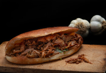 Shawarma and garlic on the wooden desk on black background