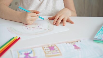 Close-up of a child's hands coloring a drawing with bright pencils. Young girl engaging in colorful artistic drawing and coloring activity using pencils. Enhancing creativity. Imagination