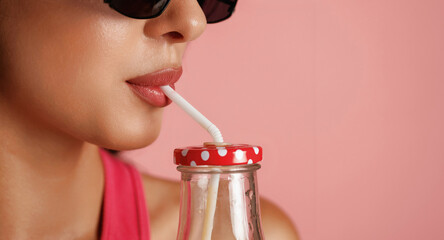 Fresh drink. Beautiful young woman is against background