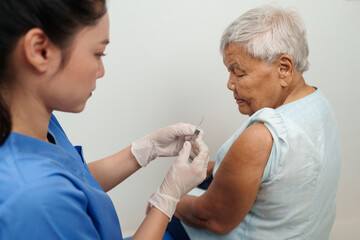 Fototapeta premium doctor make injection vaccine to senior woman