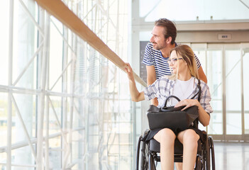 Woman using wheelchair exploring modern building with partner