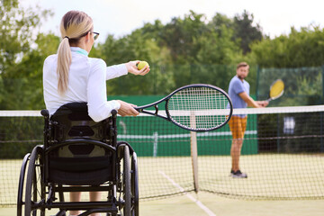 Inclusive tennis practice with a person using a wheelchair and partner on the court