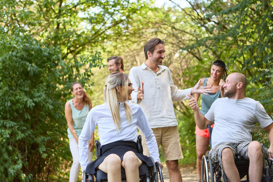 Group of friends, including people using wheelchairs, enjoying a sunny day outdoors together