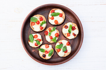 Italian mini pizza . Aubergine (eggplant ) with mozzarella cheese and basil . On rustic background