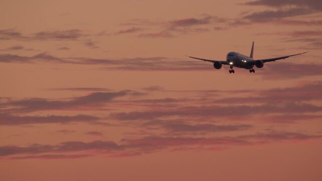 Commercial airplane descends towards a runway at sunset, creating a captivating aviation scene perfect for travel or transportation themes