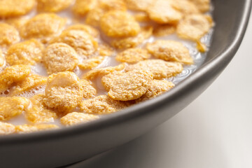 Crispy corn flakes with oat milk in a kitchen bowl ready for breakfast