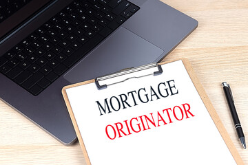 Mortgage originator text on a clipboard placed next to a laptop and pen