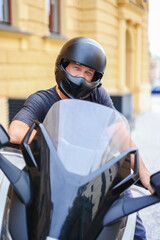 Biker in a helmet and leather protective equipment sits on a motorcycle, a sporty fast motorcycle