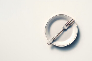 A fork lying on a clean plate. Space for text.