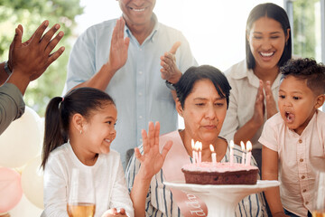 Mature woman, family and birthday with cake in applause for celebration, age or dessert together at...