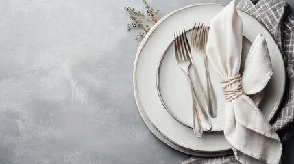 Clean Plates, Cutlery, and Napkin on Gray Table Closeup