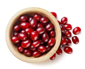 Cornel berries in a wooden plate on a white background. Dogwood berries