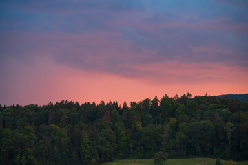 Dramatic sunset clouds over a mountain pine forest in Europe, no people