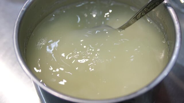 Close-up of woman hands washing white rice in colander in a bowl