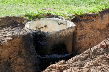 Sewer manhole installation, sewage and stormwater management systems. Concrete sewage manhole during the installation process in trench. Utility work in progress. Underground sewage systems