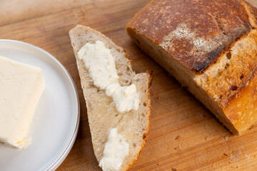 Homemade sourdough bread: a buttered slice and a loaf