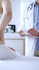 Doctor and patient. Physician is making notes on a clipboard while patient woman is describing something. Pediatrician, medicine concept