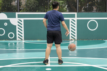 A man plays basketball while sitting on the court.