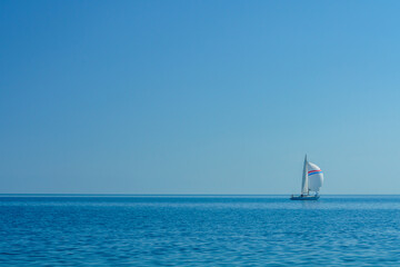 Obraz premium Sailboat navigating Issyk-Kul Lake. Sailing, maritime sport. Skilled sailors. Yacht, Wind harnessing. Boating experience