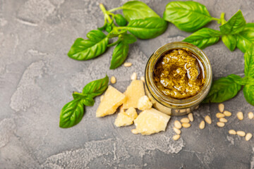 Pesto. Italian basil pesto sauce on a textured wooden background. Ingredient for pesto sauce: fresh...