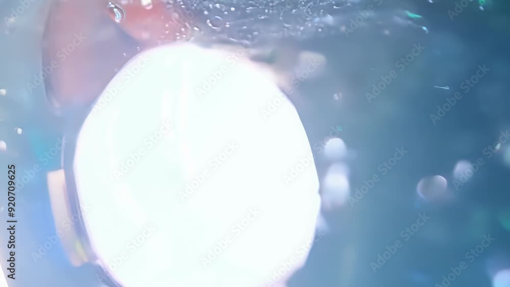 Poster watch bubbles form and rise in a vibrant liquid illuminated by bright light, creating a captivating 
