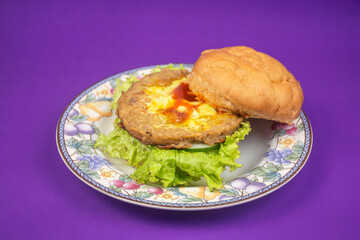 beef cheese burger on a beautiful plate isolated on purple background
