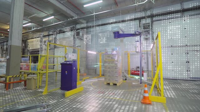 The concept of automatic packaging of goods in film. Packing boxes in film at the factory. Visualization of a modern factory