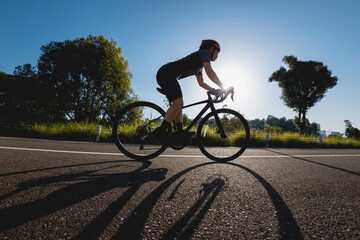 Woman cycling on summer park trail