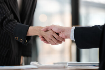 Two people shaking hands in a business setting