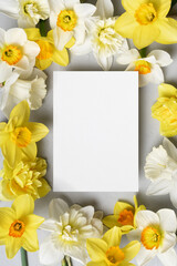 Wedding invitation or greeting card mockup with spring daffodils flowers, paper card with copy space
