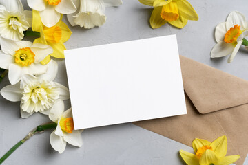 Wedding invitation or greeting card mockup with daffodils flowers and envelope, blank paper card mock up with copy space