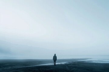 A solitary figure standing by the waterside in a foggy, tranquil landscape, wide open space, and serene atmosphere, embodying solitude and contemplation.