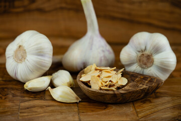 Frischer und getrockneter Knoblauch auf Olivenholz