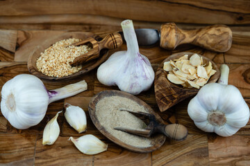 Frischer und getrockneter Knoblauch auf Olivenholz
