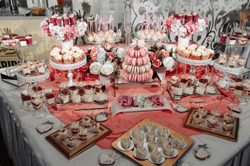A table full of desserts and pastries, including cupcakes, macarons, and cakes