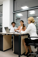 Professional team meeting in the office. Leader discussing investments and digital project management with board members. Ideal for showcasing teamwork and strategic planning.