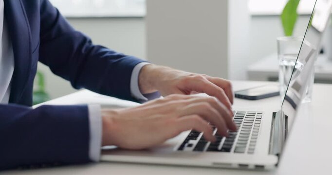 Close up of businessman opening laptop and typing on keyboard at office