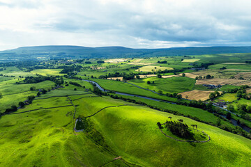 Fototapeta premium Farms and Fields over Yorkshire Dales National Park from a dron, North Yorkshire, England
