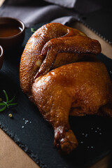 Half of smoked chicken on dark background