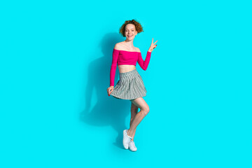 Full body portrait of lovely young girl show v-sign wear top isolated on turquoise color background