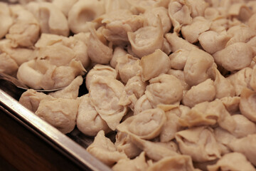 Steamed Fish ball  are piled up on a tray. Strangely shaped fish balls are placed on a tray.