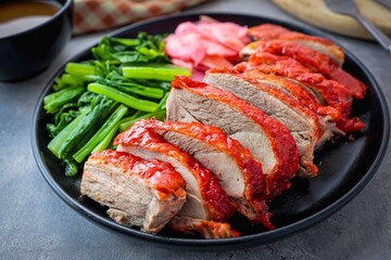 Rosted duck in black ceramic plate on cement background