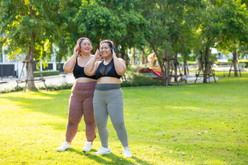 Fototapeta premium Dance, Listening music headphone. beautiful young chubby overweight woman in sportswear doing exercise outdoors at park. fitness sport club, body and health care. Activity